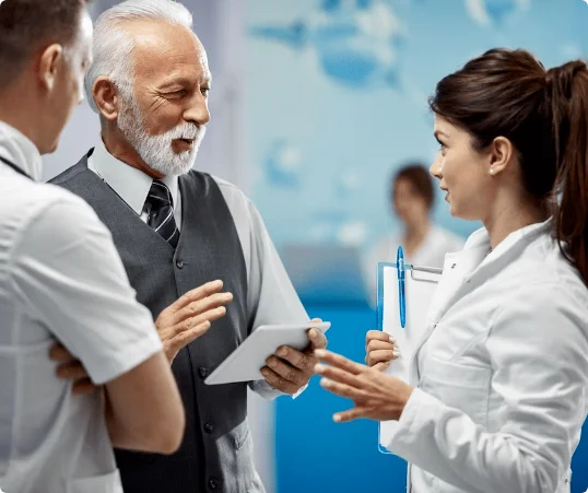 An old doctor is smiling with his colleagues